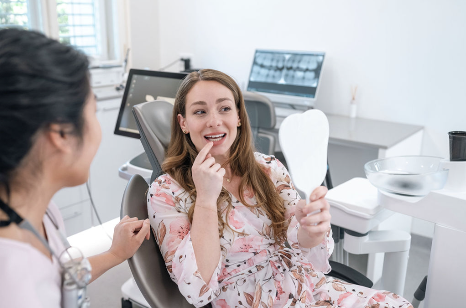 Patient showing teeth in mirror during consultation