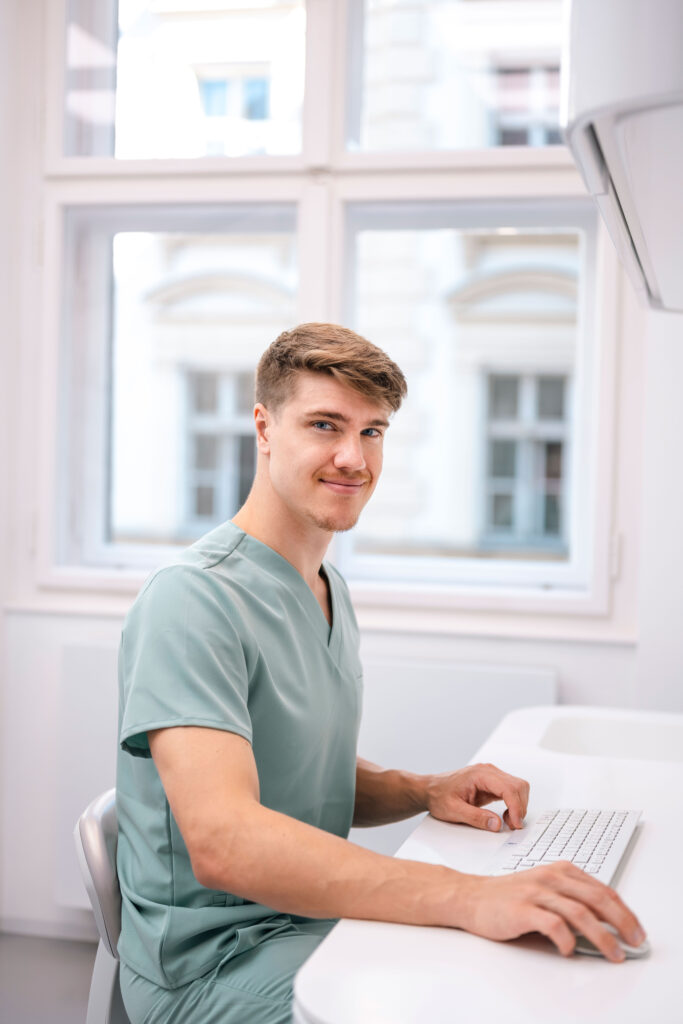 Zubní lékař pracuje u počítače v ordinaci