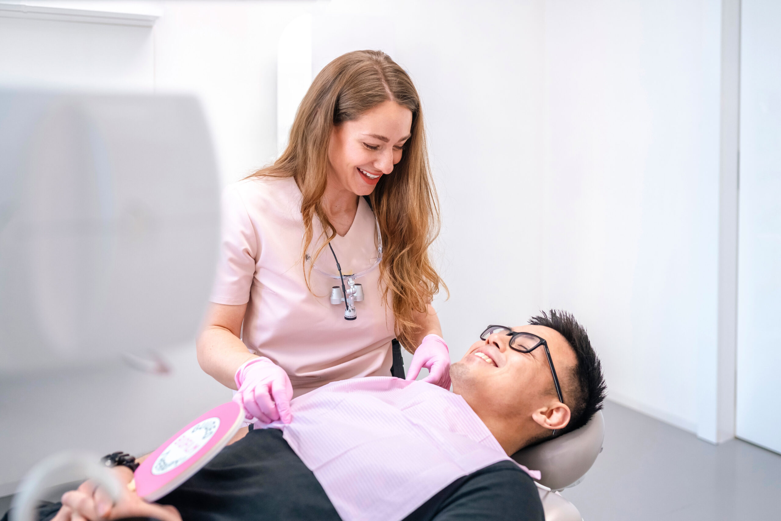 Dentální hygienistka připravuje pacienta na dentální hygienu