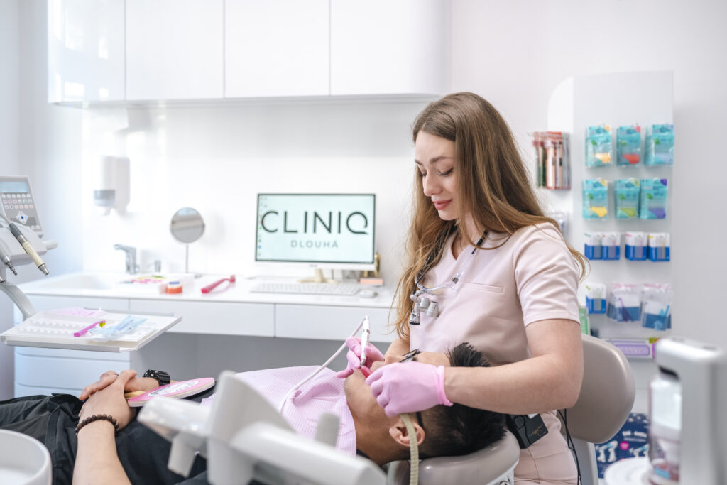 A dental hygienist treats a patient in the modern Cliniq Dlouhá dental clinic.